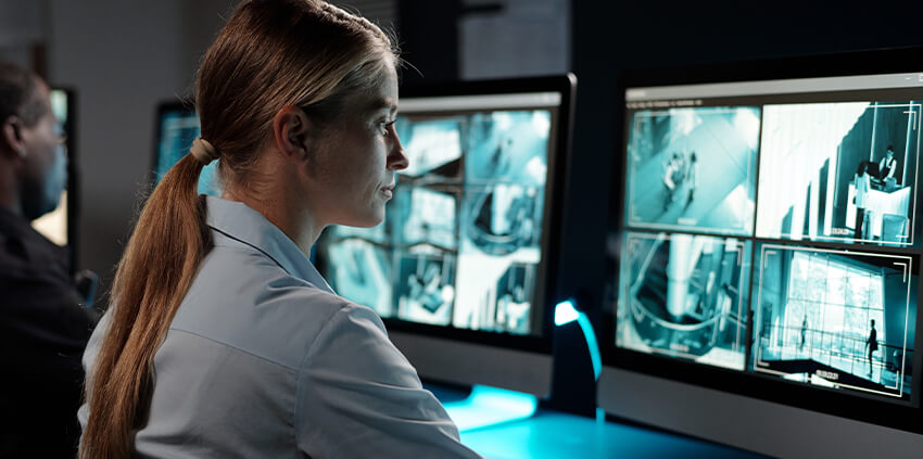 Woman monitoring computer screeens